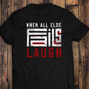 May include: Black t-shirt with a white graphic that says "WHEN ALL ELSE FAILS LAUGH" in a distressed font.