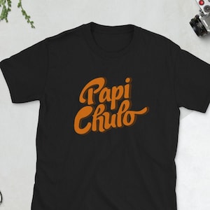 May include: Black t-shirt with a retro orange graphic that says "Papi Chulo".