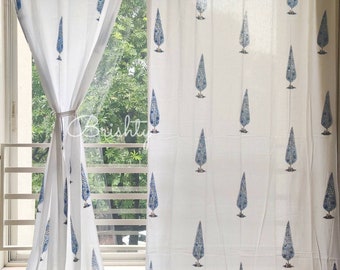 Könnte beinhalten: Weiße Baumwollvorhänge mit einem blauen Baumdruck. Die Vorhänge haben einen floralen Saum am unteren Rand.