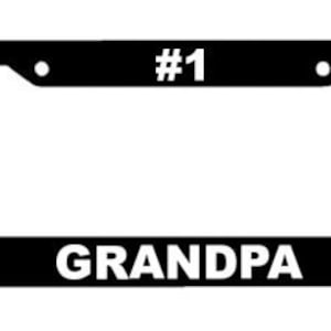 May include: Black license plate frame with white text that reads "#1 GRANDPA".