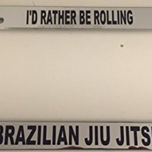 May include: A silver licence plate frame with black text that reads "I'd rather be rolling Brazilian Jiu Jitsu".