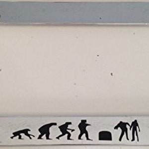 May include: A silver license plate frame with a black silhouette of the evolution of man, ending with a zombie. The frame has a white background.