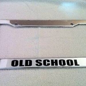 May include: Chrome licence plate frame with the words "OLD SCHOOL" printed in black.