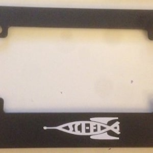 Op de afbeelding: Zwarte kentekenplaathouder met een wit raketontwerp en de tekst "SCI-FI" eronder.