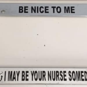 May include: A silver license plate frame with black text that reads "Be Nice To Me & I May Be Your Nurse Someday".
