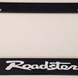 May include: Black plastic license plate frame with a white "Roadster" inscription.