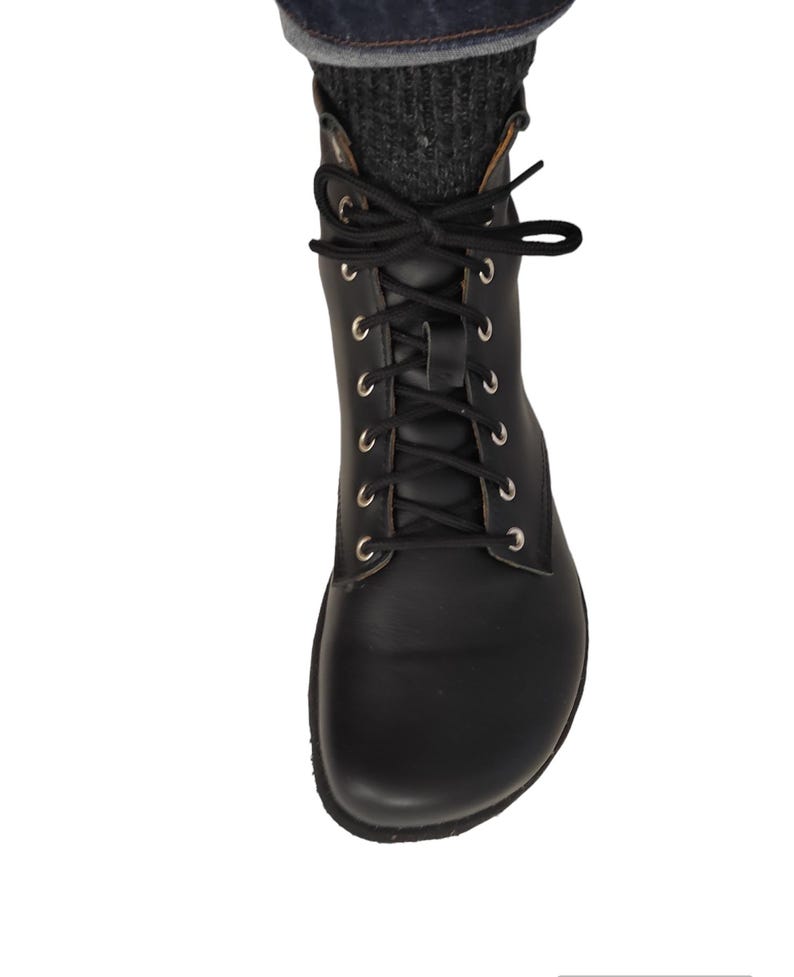 Puede incluir: Bota negra de cuero con cordones, ojales plateados y cordones negros. La bota se lleva con calcetines de punto grises y vaqueros azules. Un estilo cl&aacute;sico, adecuado para varios conjuntos.