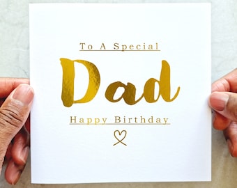 May include: A white card with gold foil lettering that says "To A Special Dad Happy Birthday" with a gold heart symbol.