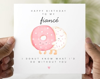 May include: A white card with a pink and white donut illustration. The card reads "Happy Birthday to my fiancé. I donut know what I'd do without you."