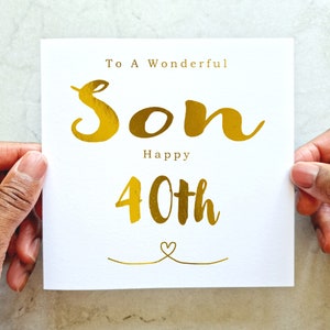 Peut inclure: Une carte blanche avec des lettres dorées qui disent "To A Wonderful Son Happy 40th" avec un petit cœur en bas.