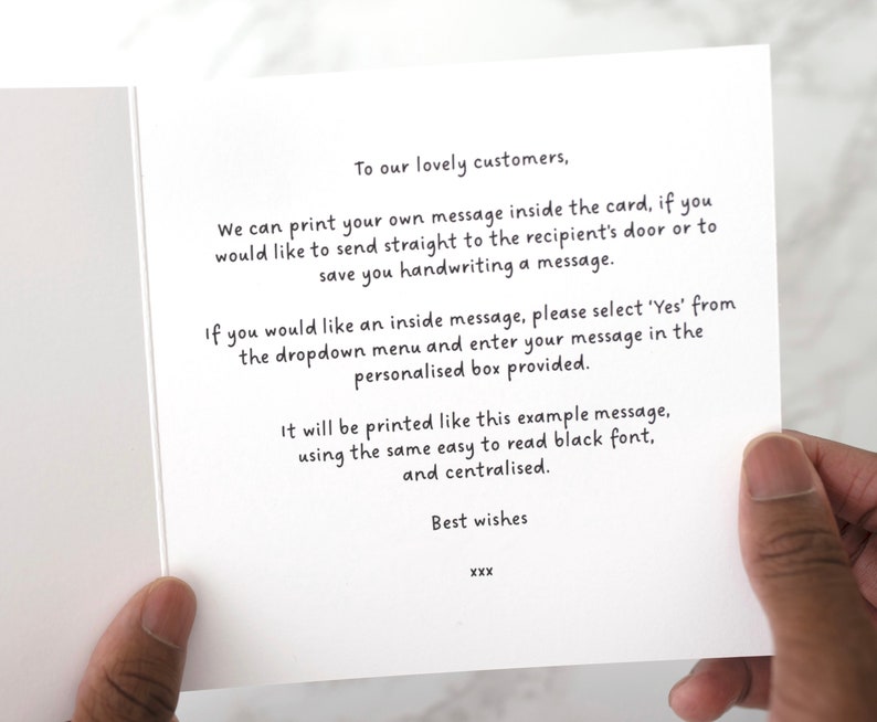 May include: An open white greeting card with black text. The text reads, "To our lovely customers...We can print your own message inside the card...Best wishes." The card is held by a person's hand.