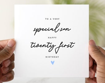 May include: A white card with black text that reads "To a very special son Happy twenty first Birthday" with a light blue heart at the bottom.