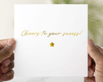 May include: A white card with gold lettering that reads "Cheers to your success!" and a gold star.