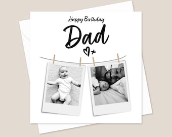 May include: A black and white birthday card with the text "Happy Birthday Dad" and a heart with a plus sign. Two black and white photos are hanging from clothespins on a string. The photos show a baby and a father with the baby.