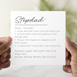 May include: A white card featuring the word "Stepdad" in a script font, with a blue heart. The card defines "Stepdad" as a man who chose to be, a bonus parent, and a hero. Synonyms include Legend and Role model.
