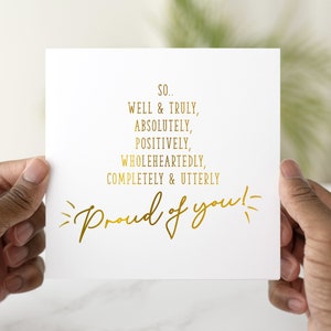 Peut inclure: Une carte blanche avec une inscription dorée qui dit "SO... WELL & TRULY, ABSOLUTELY, POSITIVELY, WHOLEHEARTEDLY, COMPLETELY & UTTERLY Proud of you!"