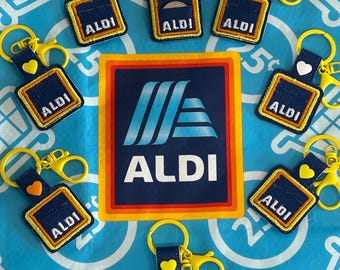 Llavero con forma de moneda de Aldi con diseño de carrito de la compra bordado en cuero vegano.