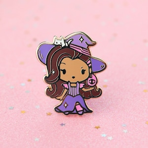 May include: A metal enamel pin featuring a cartoon character with long brown hair wearing a purple witch hat and dress. A small white cat sits on the hat brim. The character holds a pink skull-shaped object. The pin has gold-toned metal outlines.