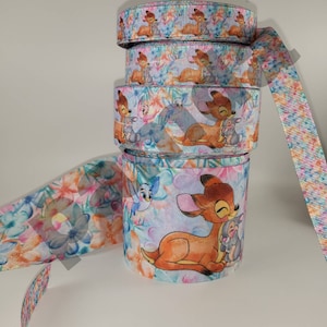 May include: A stack of colorful ribbon featuring a cartoon deer and rabbit design. The ribbon is printed with a floral pattern and has a white background.