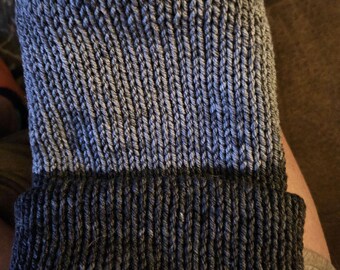 May include: A gray and black knit beanie hat with a ribbed brim.