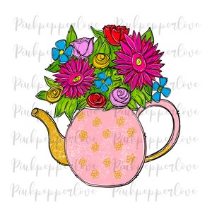 Puede incluir: Una tetera rosa con un arreglo floral de flores rosas, rojas, amarillas y azules. La tetera tiene un asa y un pico de oro y está decorada con un patrón de pequeñas estrellas doradas.