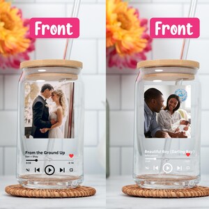 May include: Two clear glass jars with bamboo lids and straws. Each jar has a photo inside and a music player graphic with song titles and artists. The first jar has a photo of a couple and the song "From the Ground Up" by Dan + Shay. The second jar has a photo of a family and the song "Beautiful Boy (Darling Boy)" by Ben Rector.