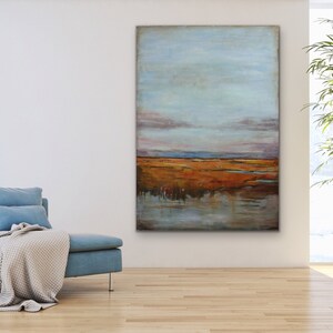 May include: Abstract landscape painting with a blue sky, orange and brown field, and a reflection of the sky in the water.