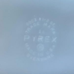 May include: Pale blue Pyrex dish with the Pyrex logo and text. The text includes "TRADE MARK" and "MADE IN U.S.A."