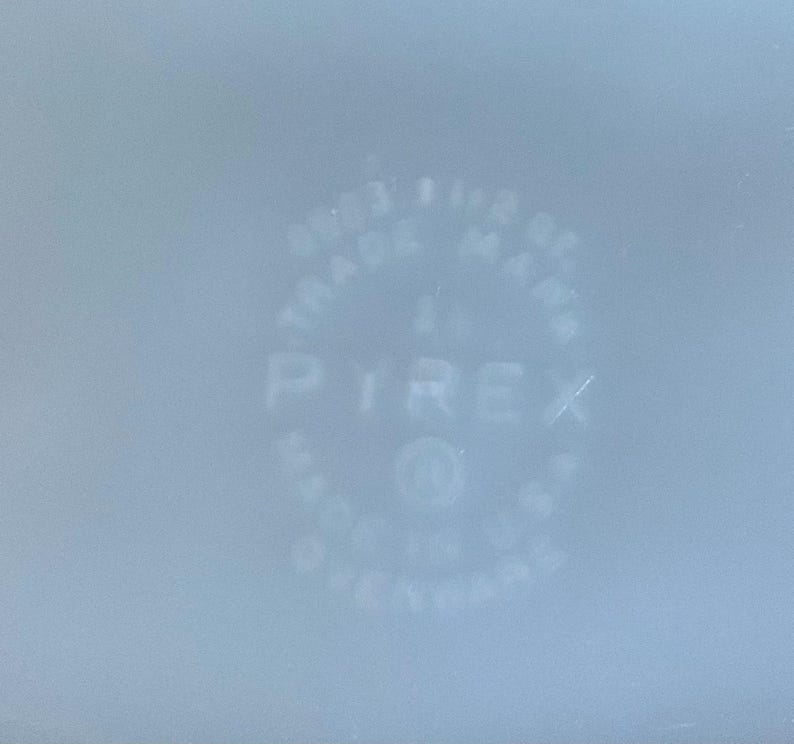 May include: Pale blue Pyrex dish with the Pyrex logo and text. The text includes "TRADE MARK" and "MADE IN U.S.A."