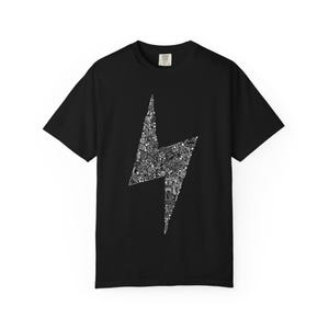 May include: Black t-shirt featuring a white lightning bolt design filled with various small illustrations. The shirt has short sleeves and a crew neck. The lightning bolt design is centered on the front of the shirt.