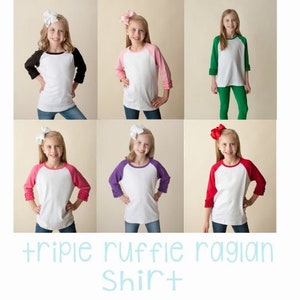 Pu&ograve; includere: Una collezione di sei maglie raglan con corpo bianco e maniche a tre quarti in nero, rosa chiaro, verde, rosa scuro, viola e rosso. Ogni manica presenta un polsino con tripla balza. Il testo recita triple ruffle ragian Shirt.