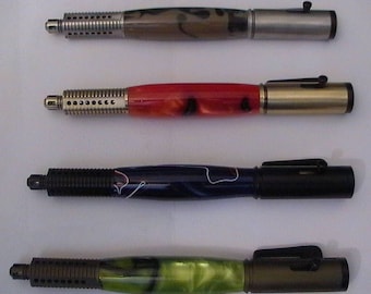 Könnte beinhalten: Vier verschiedene Stifte mit unterschiedlich farbigen Läufen und Metallakzenten. Die Stifte haben einen schwarzen Clip und eine schwarze Spitze. Die Läufe sind aus verschiedenen Materialien gefertigt, darunter Holz, Metall und Kunststoff.