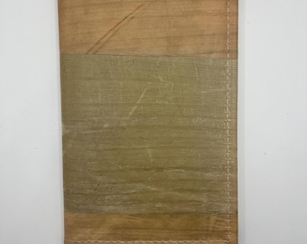May include: A brown leather wallet with a stitched seam and a light brown and green fabric panel.