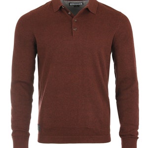 May include: A long-sleeved, burgundy polo shirt with a button-up collar and a small logo on the left sleeve. The shirt is made of a soft, textured fabric.