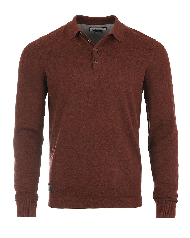 May include: A long-sleeved, burgundy polo shirt with a button-up collar and a small logo on the left sleeve. The shirt is made of a soft, textured fabric.