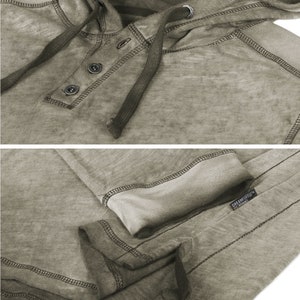 May include: A light brown hooded sweatshirt with a button-up front and a drawstring hood. The sweatshirt has a distressed look and a tag that reads "DREAMSPORT" in black text.