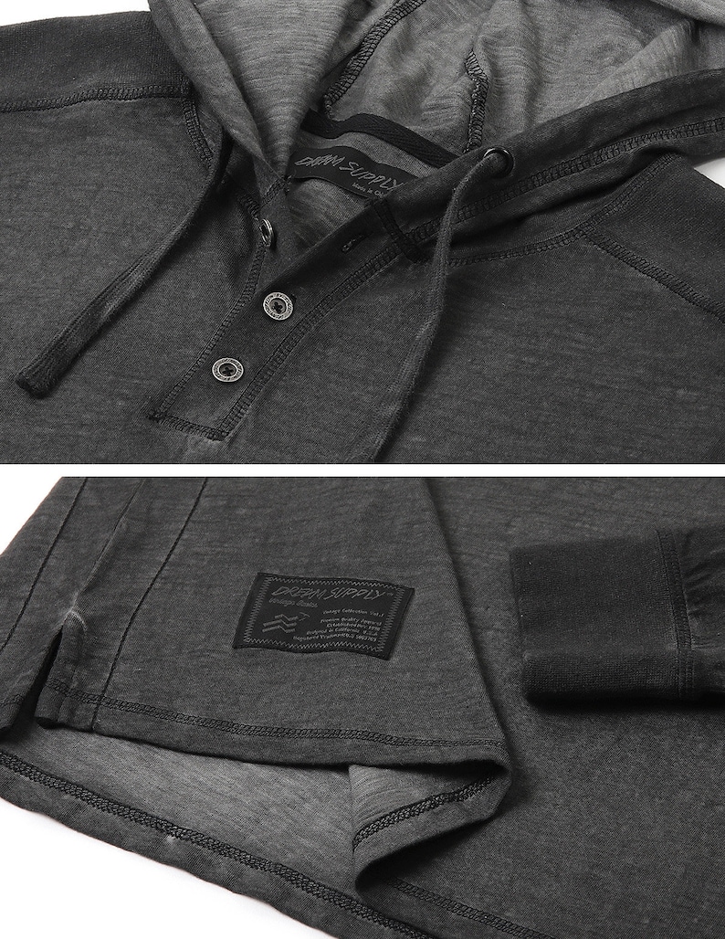 May include: A charcoal gray long-sleeve hooded shirt with a button placket and a small black label with the text "DRK SUPPLY" on the front. The shirt has a relaxed fit and a distressed look.