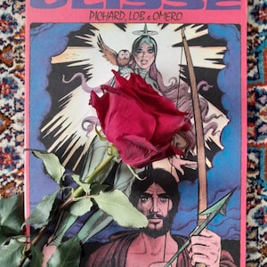 Könnte beinhalten: Ein Comicbuch mit dem Titel ULISSE von Pichard, Lob und Omero, das einen bärtigen Mann mit einem Bogen und eine Frau mit einer Eule zeigt, teilweise bedeckt von einer dunkelroten Rose mit grünem Stiel und Blättern auf rosa Grund.