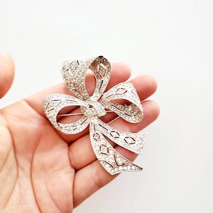 Broche con lazo o cinta de diamantes de imitación en plata, estilo vintage de los años 70, de Kenneth Jay Lane