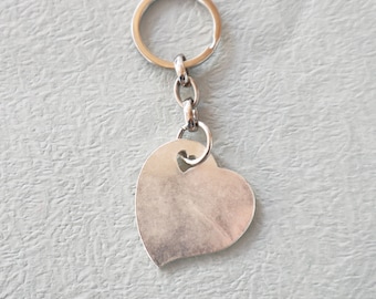 May include: A silver heart-shaped keychain with a silver ring and chain.