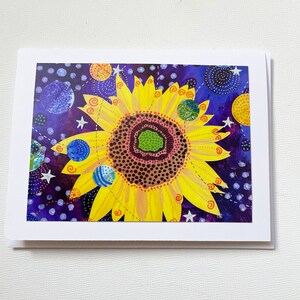 May include: A yellow sunflower with a brown centre and a green eye, surrounded by blue, green, and yellow planets on a purple background with white stars.
