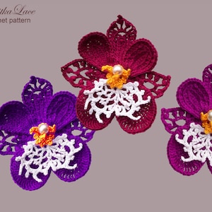 May include: Three crocheted orchid flowers featuring intricate thread work. The flowers are in shades of deep purple and magenta, with white lacy centres, yellow accents, and a central white pearl bead. Text reads Tanitka Lace crochet pattern.