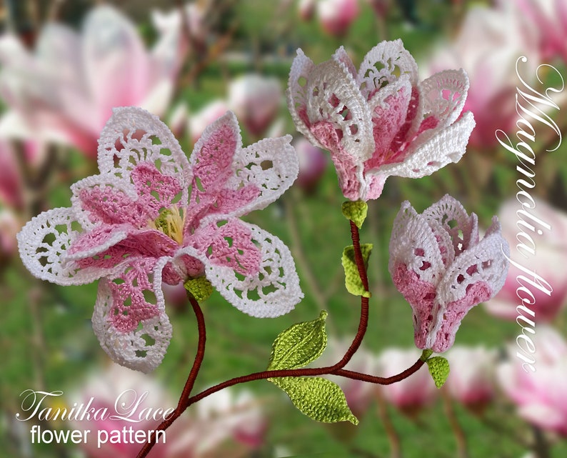 May include: Crocheted magnolia flowers in shades of pink and white, with green leaves and brown stems. The flowers are intricately detailed with a lace-like pattern. The image includes the text "Magnolia flower" and "Tanitka Lace flower pattern".