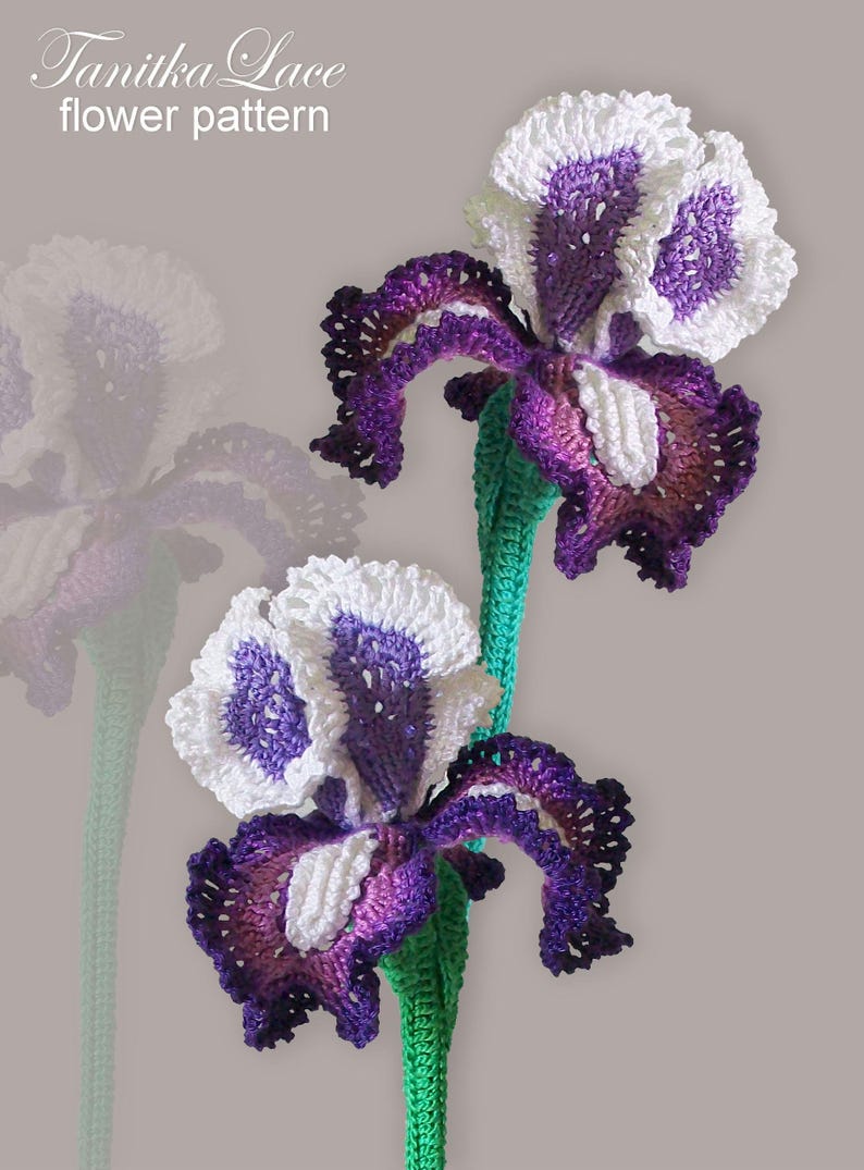 May include: Two crocheted iris flowers with white and purple petals and green stems. The flowers are handmade and feature intricate details. The text "Tanitka Lace flower pattern" is in the upper left corner.
