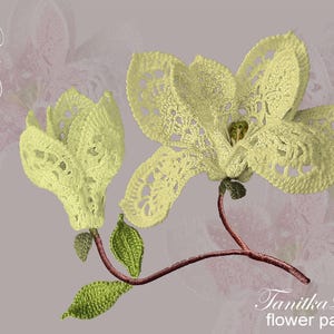 May include: A crocheted magnolia flower pattern with the text "Magnolia Flower" and "Tanitka Lace flower pattern". The flowers are light yellow with green leaves and brown stems. The background is a soft purple.