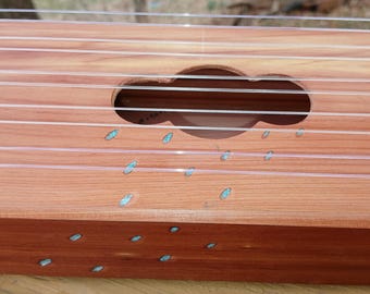 Arpa de ventana eólica. Toda de cedro aromático macizo con incrustaciones de lluvia de turquesa. 30 pulgadas de largo, 10 cuerdas. Canta agradablemente con la brisa.