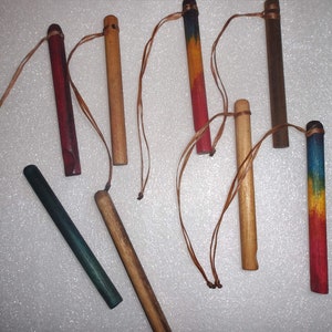 May include: Eight wooden sticks with strings attached. The sticks are painted in various colors, including red, blue, green, yellow, and brown.