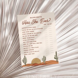 Könnte beinhalten: Ein druckbares Bachelorette-Partyspiel mit Wüsten-Thema. Das Spiel heißt "Has She Ever?" und enthält eine Liste von Fragen, die die Gäste über die Braut beantworten sollen. Die Fragen sind in brauner Schrift auf beigefarbenem Hintergrund geschrieben. Das Spiel ist mit Sonnenuntergangs- und Kaktus-Illustrationen verziert.