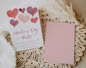 May include: A white card with pink watercolor hearts and the text "Join us for a Valentines Day Party" with details for the party on Saturday, February 14th at 6 PM. The card is on a woven straw mat with a pink card behind it.