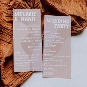 May include: Two light brown cards with white text. The left card has the text "Melanie & Noah" in a retro font. The right card has the text "Wedding Party" in a retro font. The cards list the order of events for the wedding ceremony and the wedding party.